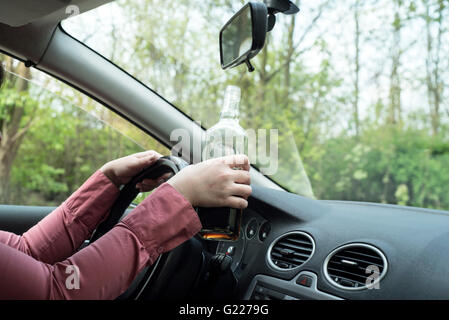 Bild der Frau Trinken von Alkohol im Auto. Stockfoto
