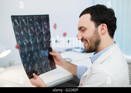Junge männliche Arzt lesen und Überprüfung einen MRI Gehirn-scan Stockfoto