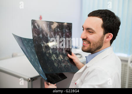 Porträt von glücklich kaukasischen männlichen Radiologe Röntgen beim Sitzen in seinem Büro halten Stockfoto