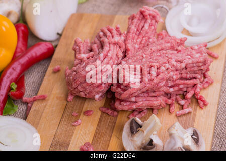 Rohes Mett und frisches Gemüse auf dem Brett Stockfoto