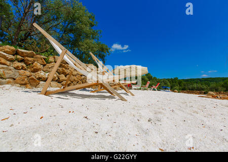 zwei gestreiften Liegestühlen am Strand Stockfoto