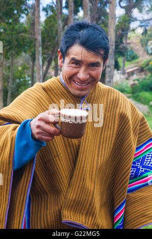 Peruanische Dorfbewohner trinken Maisbier in einem Ritual Pachamama für eine gute Ernte zu danken Stockfoto