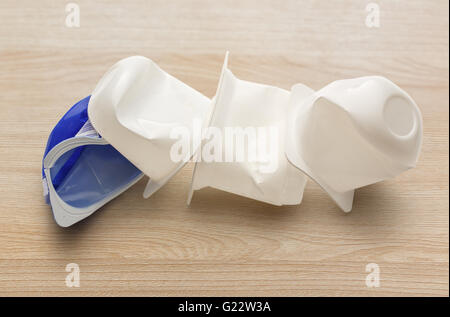 Leere zerkleinert Kunststoff Joghurtbecher auf hölzernen Hintergrund Stockfoto