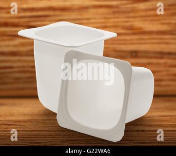 Leere zerkleinert Kunststoff Joghurtbecher auf hölzernen Hintergrund Stockfoto