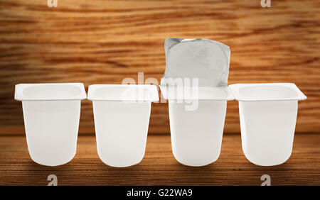 Leere zerkleinert Kunststoff Joghurtbecher auf hölzernen Hintergrund Stockfoto