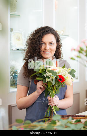 Lächelnd, hübsche junge Frau Florist genießen arbeiten im Blumenladen Stockfoto