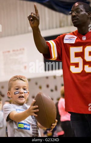 Joplin, Missouri, USA. 20. Mai 2016. Kinder in Joplin Familie YMCA Fit Kids Armee abwechselnd 6 Trainingsbereiche. Dieser Abschnitt besteht aus '' Running Back Beulen '', die ein Kind vor einer endgültigen Fußball fangen abgeschlossen werden muss. Übung, Interaktivität, Unterricht und Spiel sind alle in einer einstündigen spielen 60 Klinik Programm koordiniert die Chiefs Community-Pflege-Team kombiniert. © Serena S.Y Hsu/ZUMA Draht/Alamy Live-Nachrichten Stockfoto