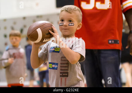 Joplin, Missouri, USA. 20. Mai 2016. Kinder in Joplin Familie YMCA Fit Kids Armee abwechselnd 6 Trainingsbereiche. Dieser Abschnitt besteht aus '' Running Back Beulen '', die ein Kind vor einer endgültigen Fußball fangen abgeschlossen werden muss. Übung, Interaktivität, Unterricht und Spiel sind alle in einer einstündigen spielen 60 Klinik Programm koordiniert die Chiefs Community-Pflege-Team kombiniert. © Serena S.Y Hsu/ZUMA Draht/Alamy Live-Nachrichten Stockfoto