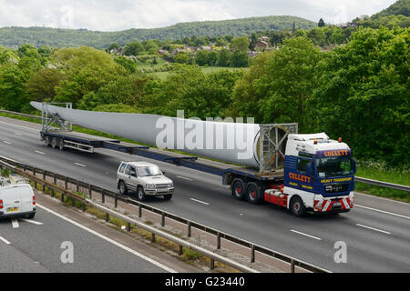 Helsby, Cheshire, UK. 23. Mai 2016. Eine 45 Meter lange Wind Turbinenschaufel unter Polizeieskorte transportiert werden. Das Fahrzeug ist aus dem Hafen von Liverpool gereist und Ausfahrt 14 der Autobahn M56 Frodsham Windpark-Projekt im Bau befindlichen Kabels nähert. Andrew Paterson/Alamy Live-Nachrichten Stockfoto