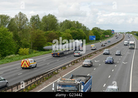 Helsby, Cheshire, UK. 23. Mai 2016. Eine 45 Meter lange Wind Turbinenschaufel unter Polizeieskorte transportiert werden. Das Fahrzeug ist aus dem Hafen von Liverpool gereist und Ausfahrt 14 der Autobahn M56 Frodsham Windpark-Projekt im Bau befindlichen Kabels nähert. Andrew Paterson/Alamy Live-Nachrichten Stockfoto