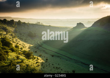 Cressbrook Dale, Peak District National Park. Derbyshire, UK. 23. Mai 2016. UK-Wetter: Erste Licht bricht über Peter Stein und beleuchtet die Ufern des Cressbrook Dale, Derbyshire. Einem schönen Frühlingsmorgen in den Peak District National Park, England, UK. Bildnachweis: Graham Dunn/Alamy Live-Nachrichten Stockfoto