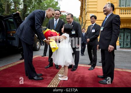 Hanoi, Vietnam. 23. Mai 2016. US-Präsident Barack Obama mit Präsidenten Tran Dai Quang, präsentiert einen Blumenstrauß von Nguyen Phuong Linh, 8, bei der Ankunft am Präsidentenpalast vor einer Ankunft Zeremonie 23. Mai 2016 in Hanoi, Vietnam. Pham Quang Vinh, vietnamesische Botschafter in den USA ist auf der rechten Seite. Bildnachweis: Planetpix/Alamy Live-Nachrichten Stockfoto