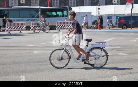 Ein Besuch junge in einem schnellen Start auf ein Gobike Elektromotor unterstützt Citybike in Copenhagen Straßen in Christiansborg. Kopenhagen, Dänemark. Stockfoto