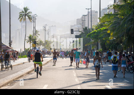 RIO DE JANEIRO - 6. März 2016: Radfahrer teilen die autofreien Avenida Vieira Souto Straße mit Passanten am Strand von Ipanema. Stockfoto