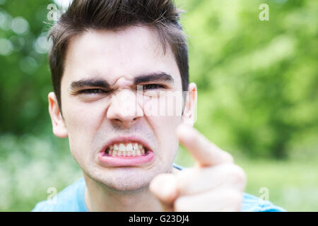 Im freien Kopf und Schultern Porträt von Angry Young Man Stockfoto