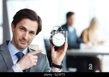 Geschäftsleute in Büro mit Wecker, Frist-Konzept Stockfoto