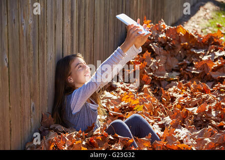 Schen Kind Mädchen Selfie TabletPC im Herbst Blätter park Stockfoto