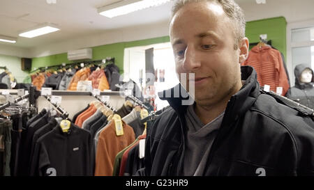 Shopping für Kleidung Mann und spricht mit Kasse Stockfoto