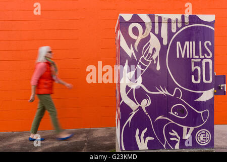 Eine Frauen-Spaziergänge vorbei an street-Art Kennzeichnung Stadtteil Artsy Mills 50 in Orlando, Florida. Stockfoto