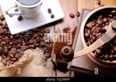 Kaffeemühle mit dampfenden Kaffee Bohnen in der Hintergrund-Draufsicht Stockfoto