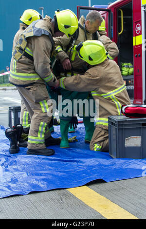 Zum Schutz gegen Chemikalien und Gasen Feuerwehrmann ein Gas engen Anzug anziehen. Stockfoto