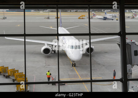 Lufthansa Flug von Frankfurt, Ankunft am Flughafen Billund, Dänemark. Embraer Jets in der Abfahrt Bereichsfenster gerahmt. Stockfoto