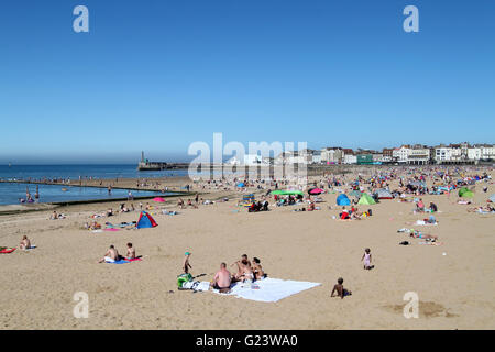 Menschen genießen den Sonnenschein an einem sonnigen Tag am Strand von Margate in East Sussex, England Stockfoto