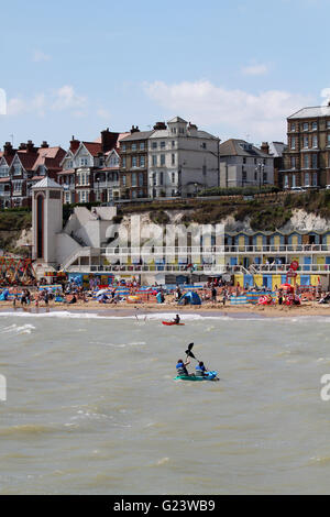 Menschen genießen den Sonnenschein an einem sonnigen Tag am Strand von Broadstairs in Kent, England Stockfoto