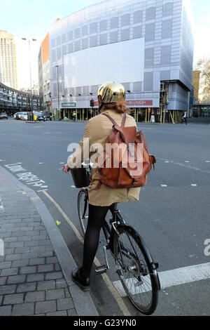 Junge weibliche Radfahrer mit einem goldenen Helm und Leder Rucksack auf Fahrrad an Goswell Road & Old Street London UK KATHY DEWITT Stockfoto