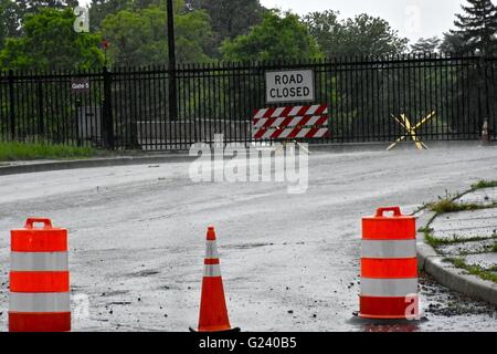 Eine überflutete Straße geschlossen mit orange Leitkegel und eine Straße geschlossen Schild an einem Tor Stockfoto