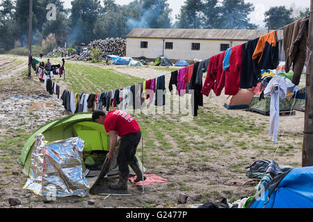 Ein Flüchtling aus Syrien reinigt sein Zelt nach starkem Regen am 17. März 2015 im Flüchtlingslager Idomeni, Griechenland. Stockfoto