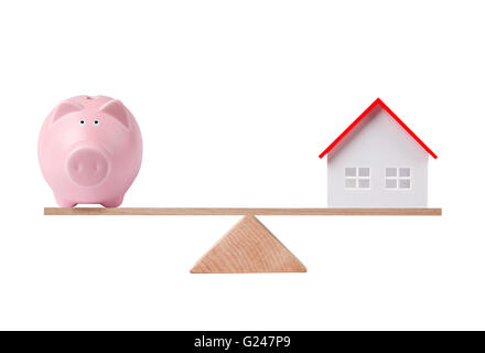 Ersparnisse und Investitionen für Haus, Balance mit Sparschwein und Häuschen Stockfoto