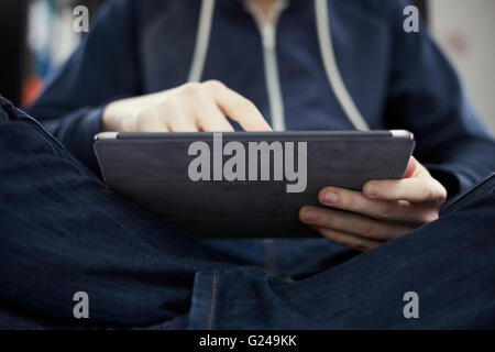 Mann mit dem Apple iPad beim Sitzen nach unten Stockfoto