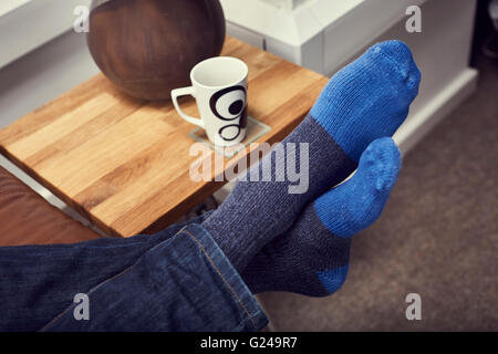 Entspannen auf dem Sofa mit Kaffee und Füße hoch Stockfoto