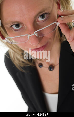 Geschäftsfrau, die über den Rand ihrer Brille Stockfoto