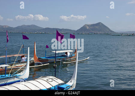 Boote am Ufer des Lake Taal, mit Vulkan-Insel in den Rücken, Luzon, Philippinen Stockfoto