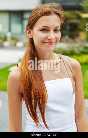 Lächelnde junge Frau mit lange brünette Haare im freien Stockfoto