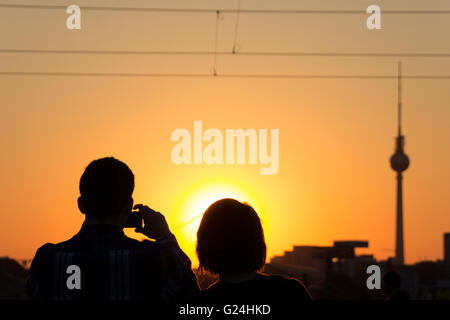 paar unter Bild Sonnenuntergang Himmel und Fernsehturm Stockfoto