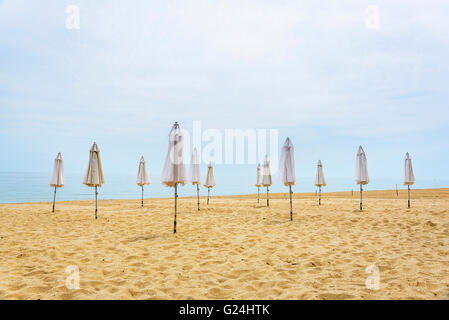 Sonnenschirm am Strand gefaltet. Konzept saisonale Urlaubszeit. Stockfoto