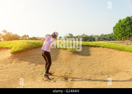 Asiatische Frau Golfer schlagen Golfball aus einem Sandfang Stockfoto