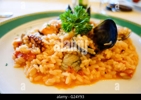 Ein Teller mit Meeresfrüchte Risotto mit Reis Muscheln Tintenfisch Tintenfisch und verschiedenen Schalen Stockfoto