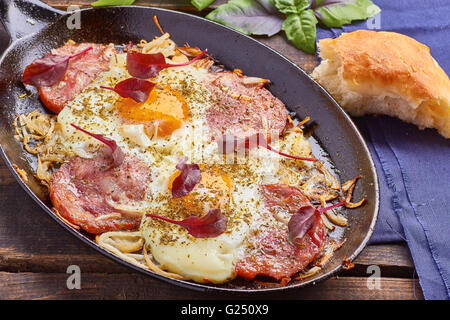 Pfanne Spiegeleier mit Zwiebeln, Schinken und Mangold Stockfoto