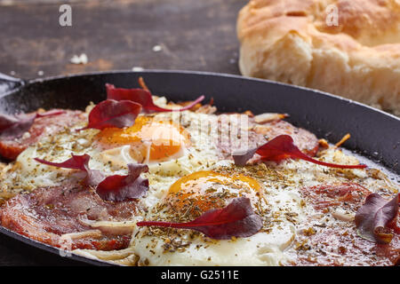 Pfanne Spiegeleier mit Zwiebeln, Schinken und Mangold Stockfoto