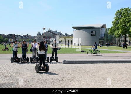Touristen auf Segways am Museumplein (Museumsplatz), Amsterdam, Niederlande im Hintergrund das Konzert Halle & Van Gogh Museum. Stockfoto