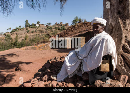 Porträt von lokalen Mann mit Saint George Felsen gehauene Kirche im Hintergrund Lalibela, Äthiopien Stockfoto