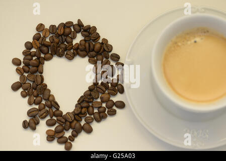 Tasse Kaffee und Kaffeebohnen in Form eines Herzens Stockfoto