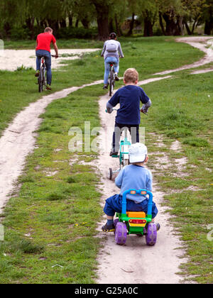 Familie Radfahren entlang der Straße in einer ländlichen Gegend Stockfoto