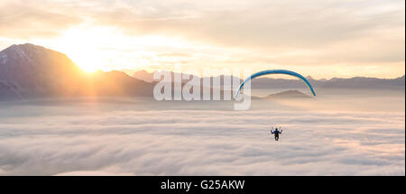 Mann-Paragliding über Wolken, Alpen, Salzburg, Österreich Stockfoto