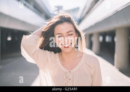 Porträt einer lächelnden Frau mit Haaren im Wind wehen Stockfoto