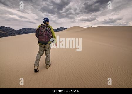 Mann, der durch Eureka Sand Dunes, Death Valley National Park, Kalifornien, USA läuft Stockfoto